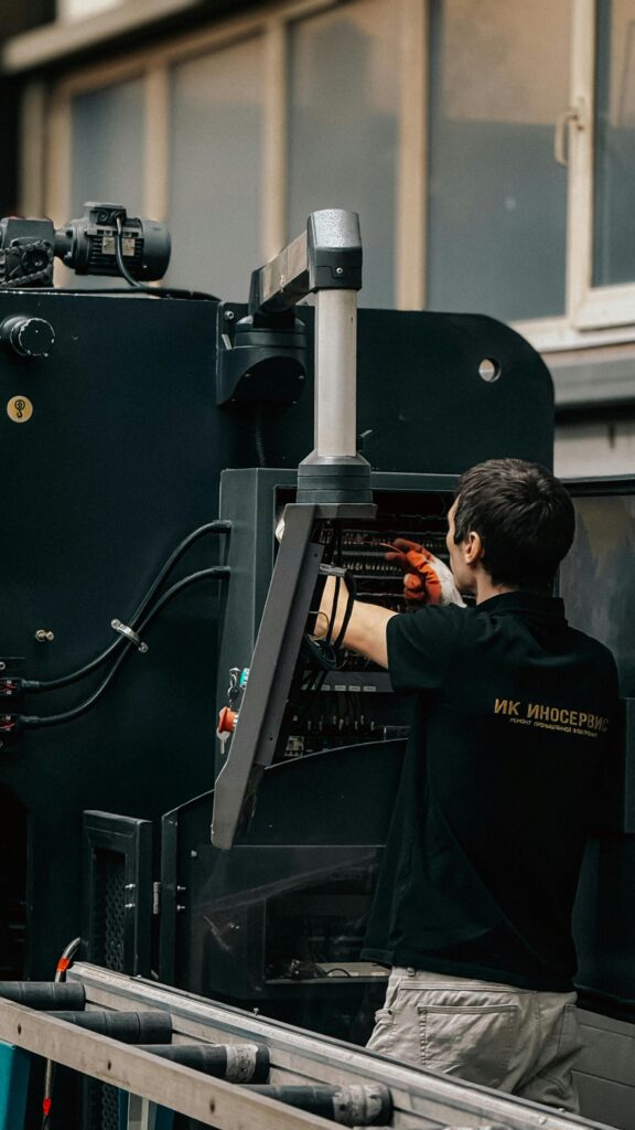 Technician working on complex industrial machinery inside a facility.