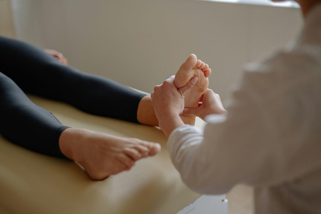 Dor nos pés, sobrecarga muscular e desconforto? 6 Close-up of a foot massage therapy session with a therapist working on a client's foot.