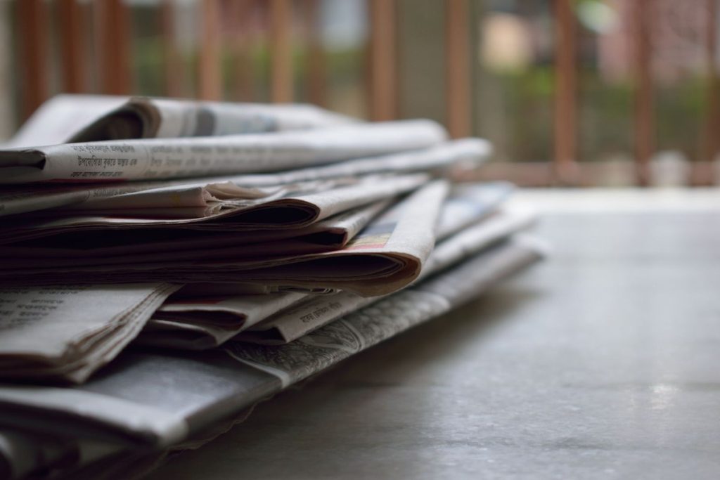 Pilha de jornais impressos sobre a mesa — jornalismo local de Americana
